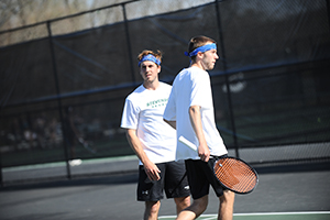 Senior Peter Hoblitzell and junior Bryan Gieselman strategize between points in their doubles match against Hood College. (Photo by Sabina Moran)
