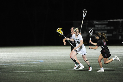 Senior Olivia Monteiro evades two defenders in a big win against Washington College. (Photo by Sabina Moran)