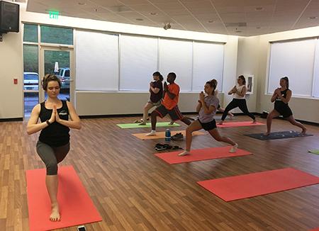 Tyler Didra, student fitness trainer, teaching a yoga course in the Fitness Center in Wooded Way. Photo by Dannielle Decastro.