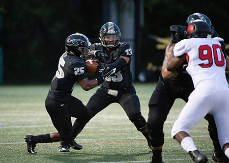 Titus Johnson anticipates the hand-off from Dan Williams as the Mustangs look to drive the ball downfield. (Photo by Sabina Moran) 