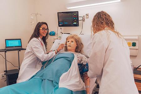 Senior nursing majors Juli Serje and Taylor George practice taking patients vitals in the simulation laboratory. (Photo by Wornden Ly)