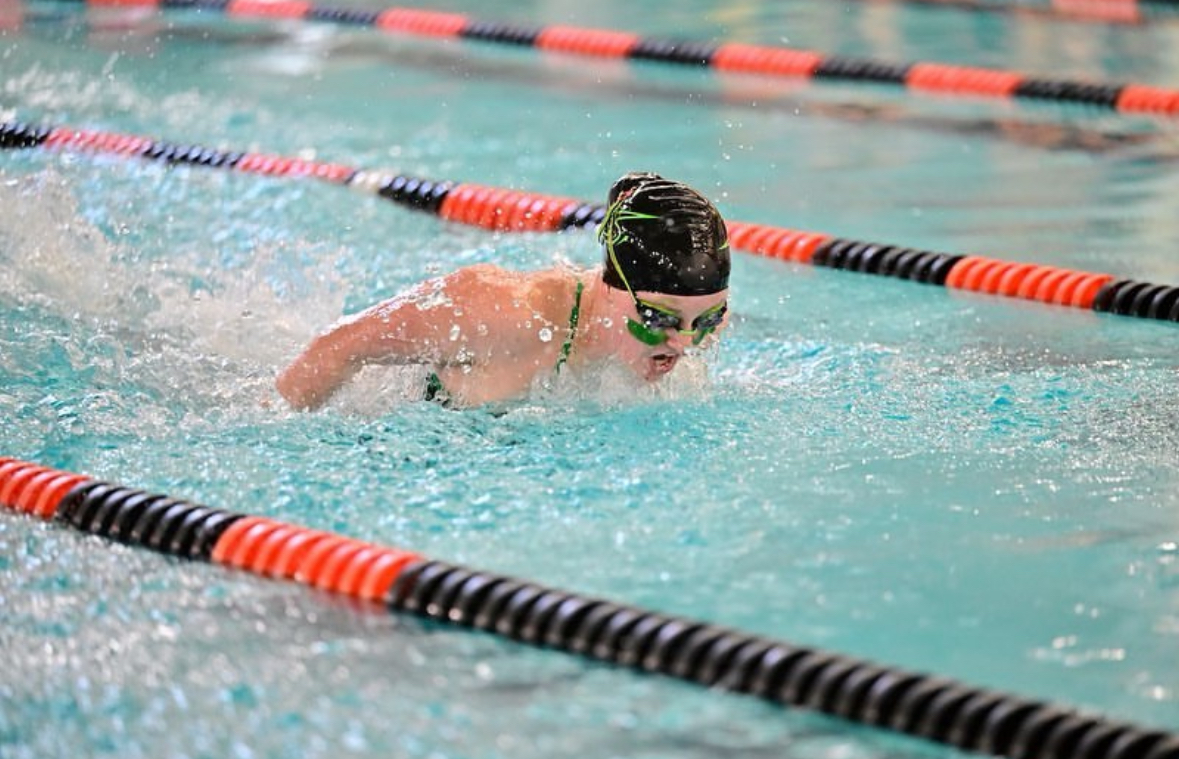 Sophomore Hailey Buenemann springs out of the water during butterfly.