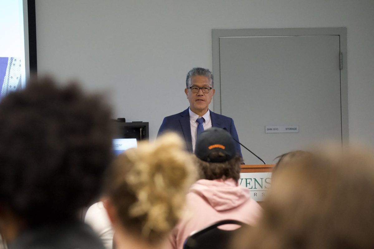 Baltimore Banner reporter Hugo Kugiya speaks to a Stevenson University audience Thursday on the value of human creativity in the age of artificial intelligence during the 16th annual Shapiro-Rouse Lecture in Garrison Hall North's Claire Moore Room.