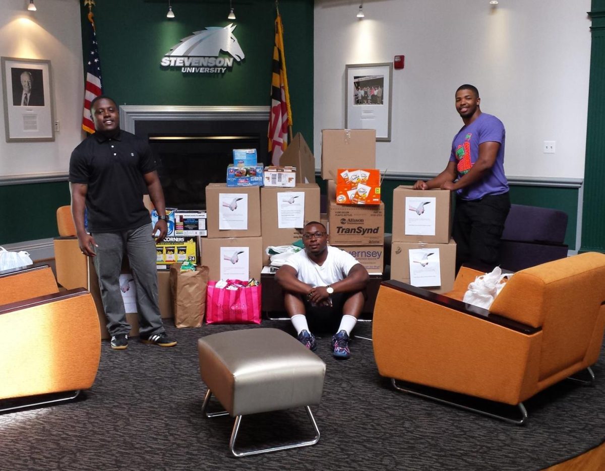 Alphonso Mayo, Donnuelle Durham and David Parker (left to right) deliver boxes full of canned goods to Sarah's Hope.