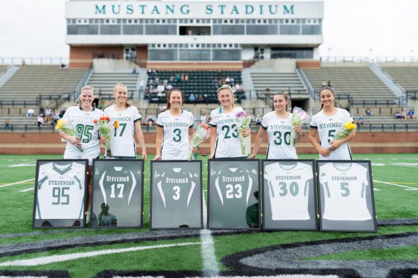 Women's Lacrosse seniors stand together prior to their senior day game.