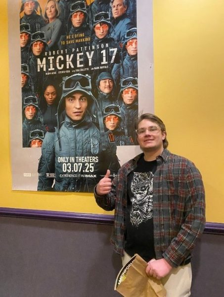 This is me posted up with two different Mickey 17 posters at the theater