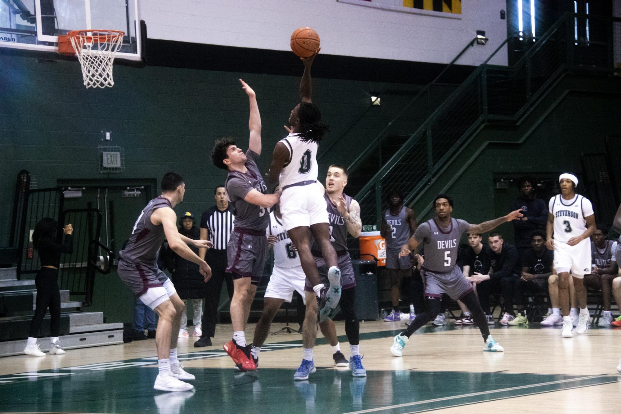 Third-year guard Christian Jackson jumps for the net, reaching over his FDU opponent.